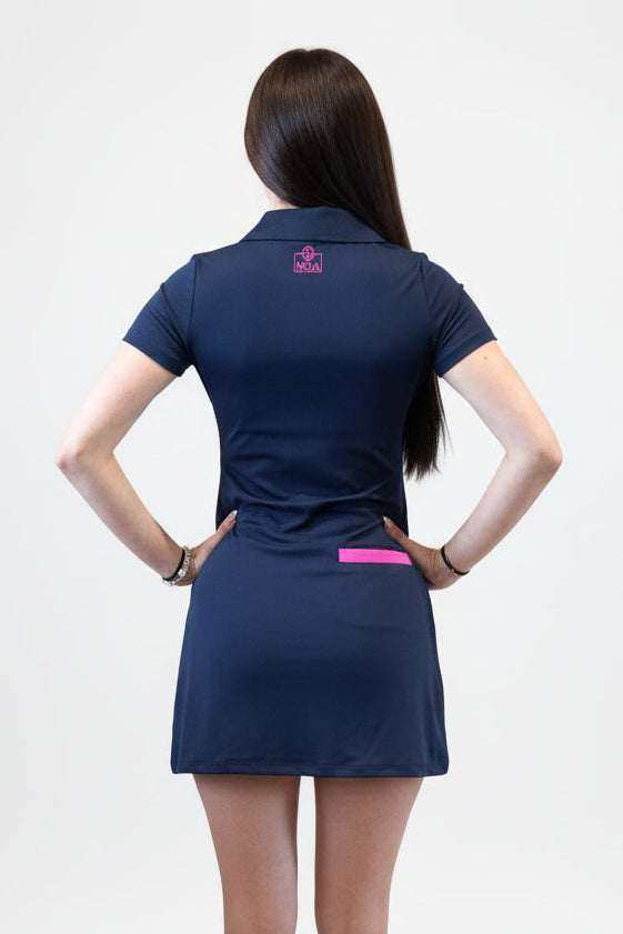 woman wearing a navy blue sneak peek dress with pink accents